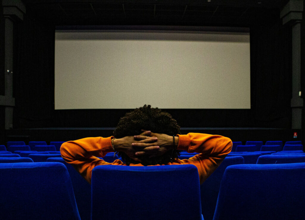 退屈そうに映画を見ている男性